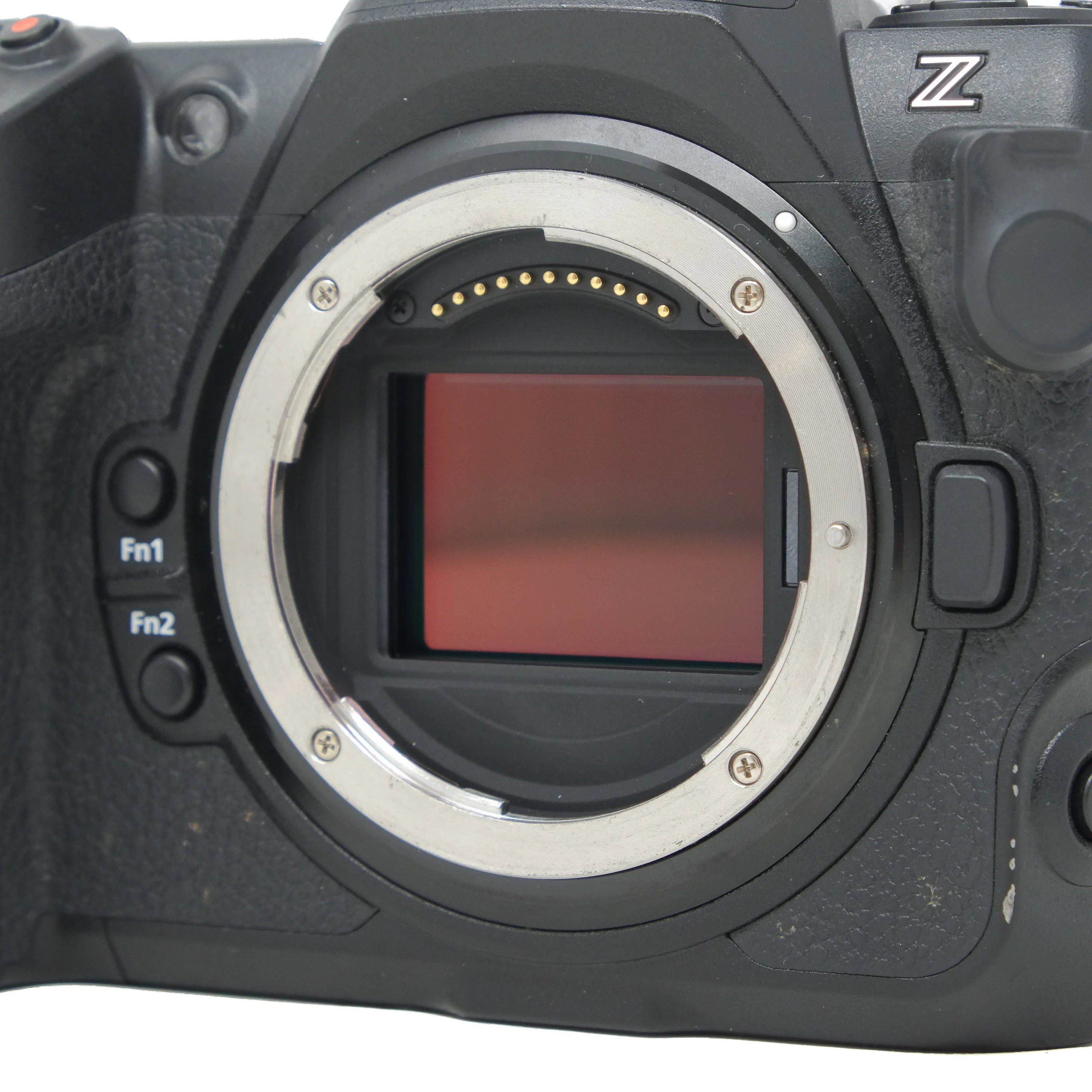 Close-up of a camera body without a lens, showing the sensor and brand logo.