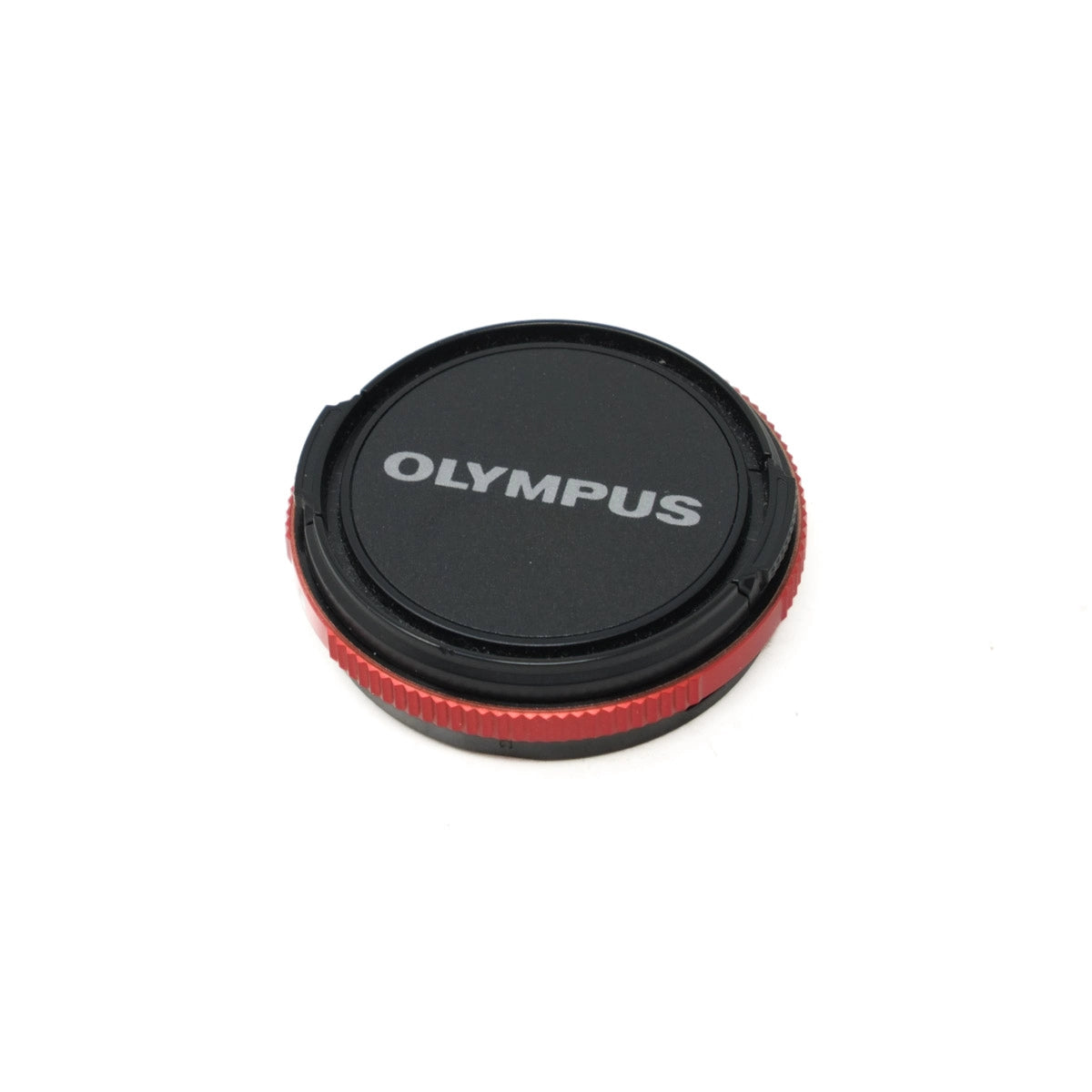 Olympus camera lens cap on a white background