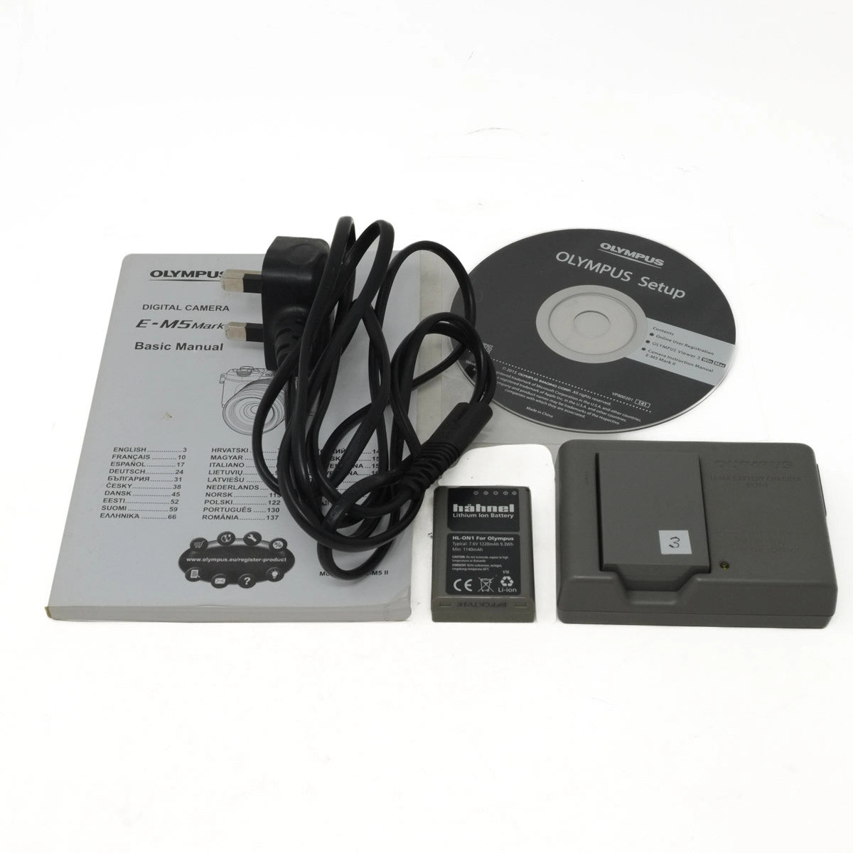 Olympus digital camera accessories including manual, battery, charger, and CD on a white background