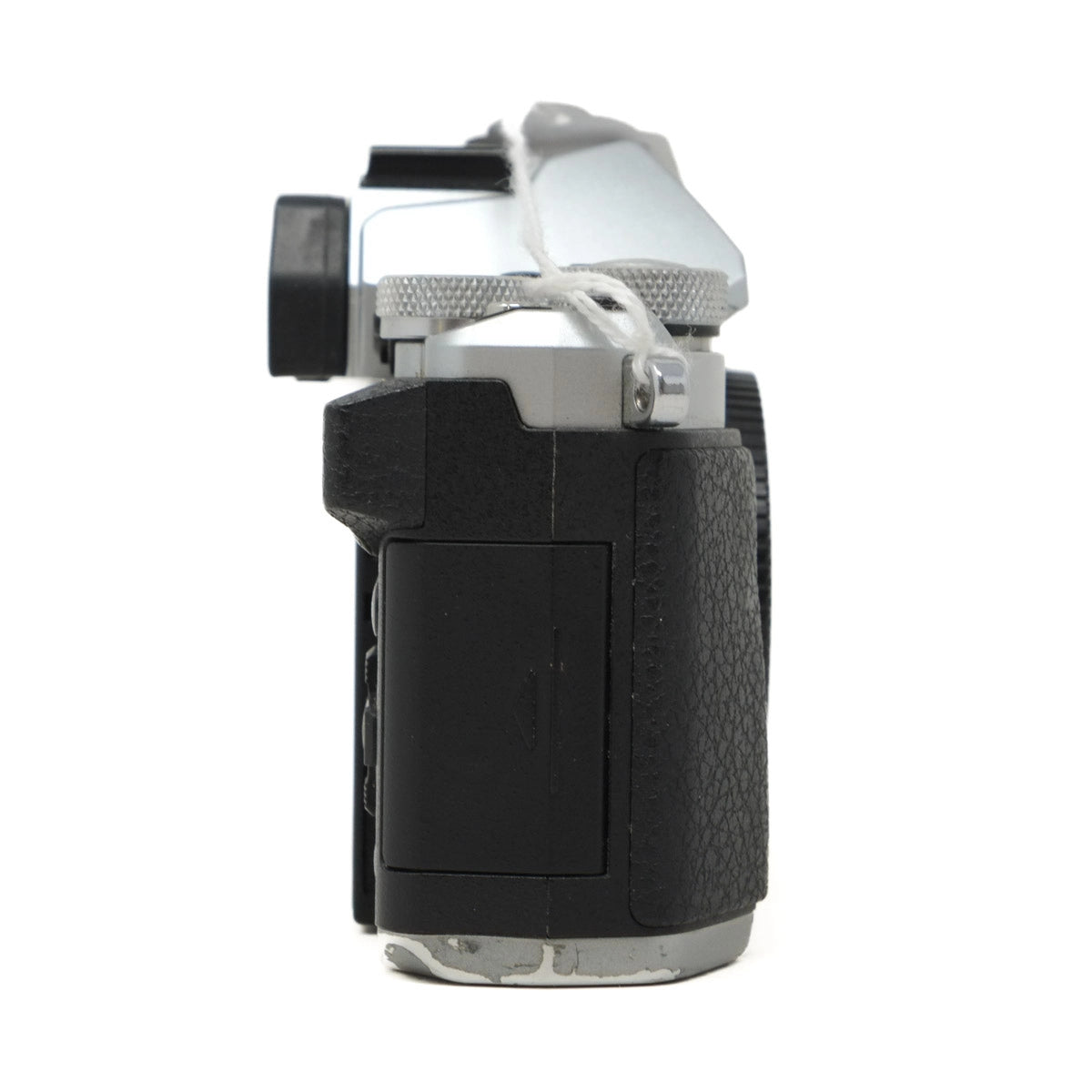 Close-up of a camera body with a black grip and silver top on a white background