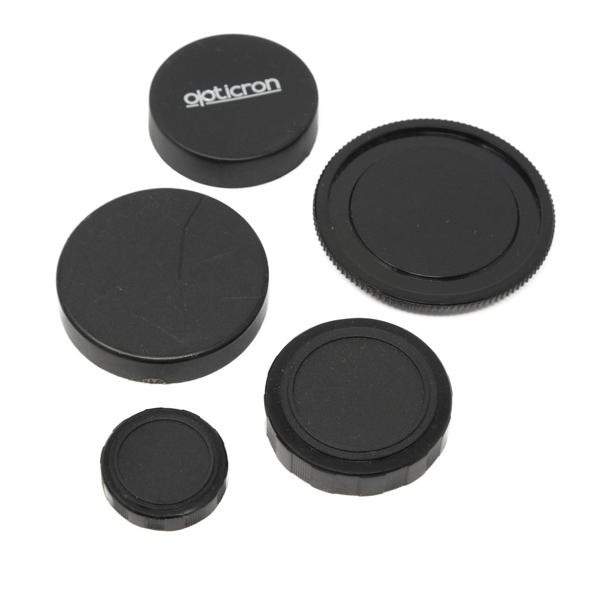 Set of black camera lens caps with 'opticron' branding on a white background