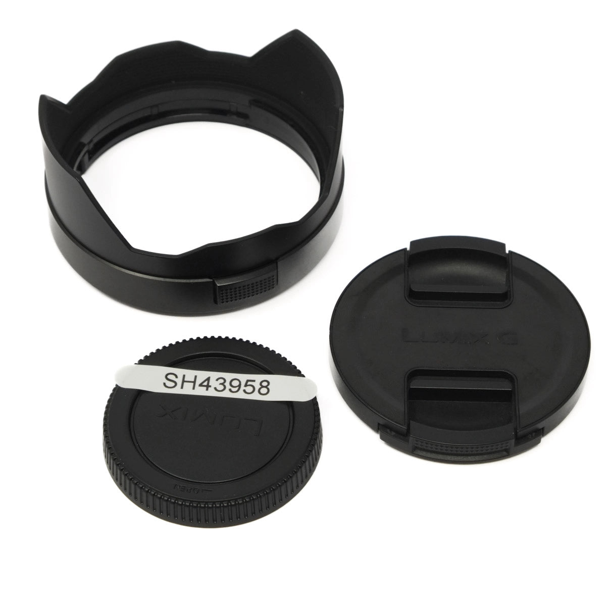Camera lens cap, hood, and body cap on a white background