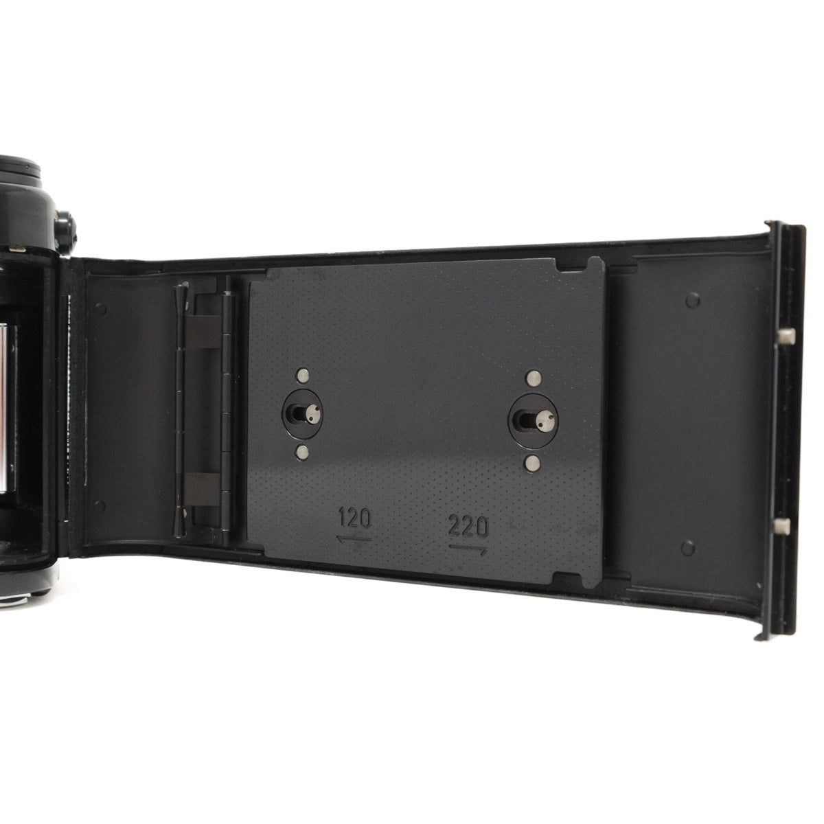 Open camera body with film back on a white background