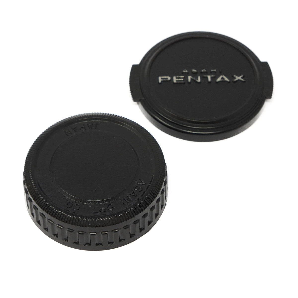 Black Pentax camera lens caps on a white background