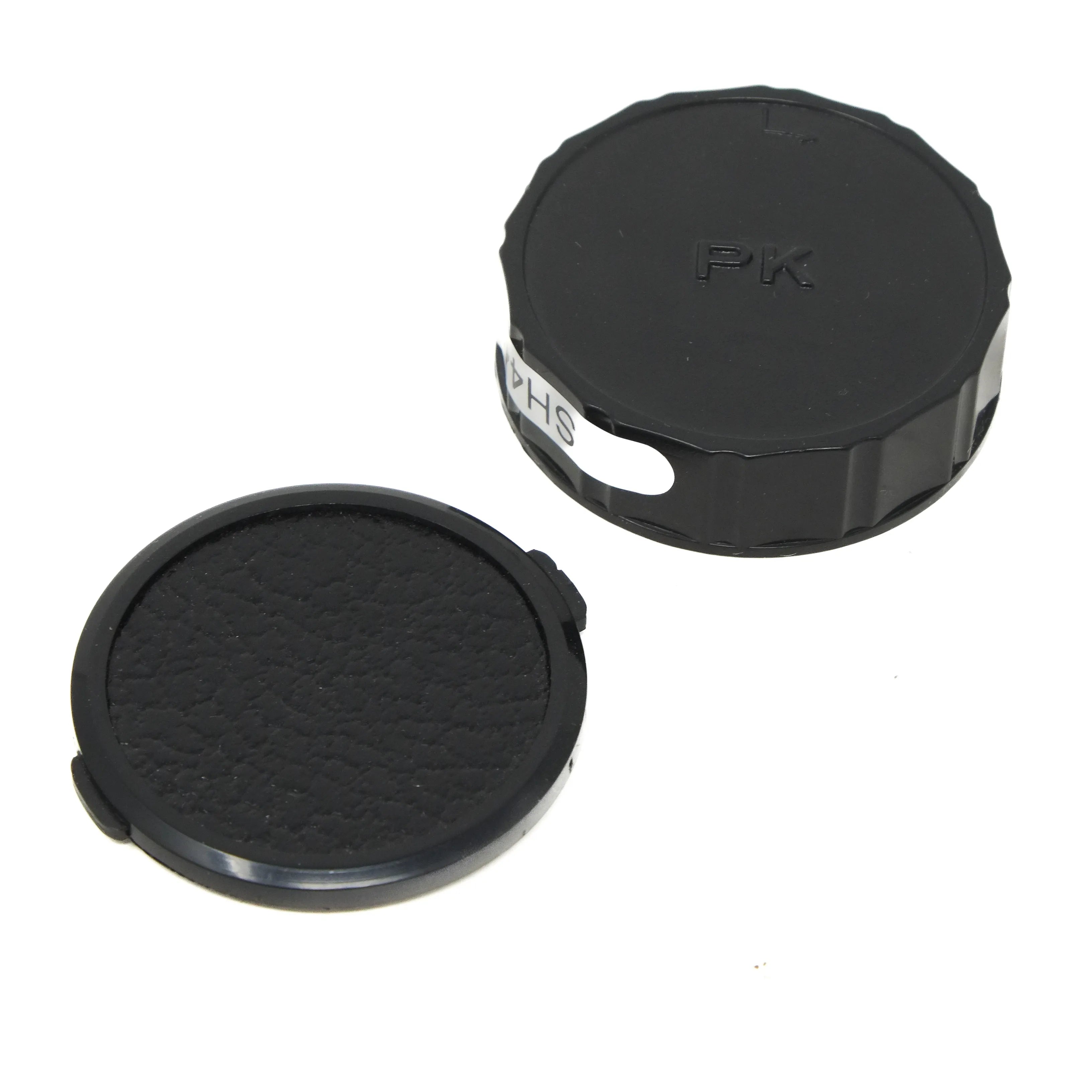 Two black camera lens caps on a white background
