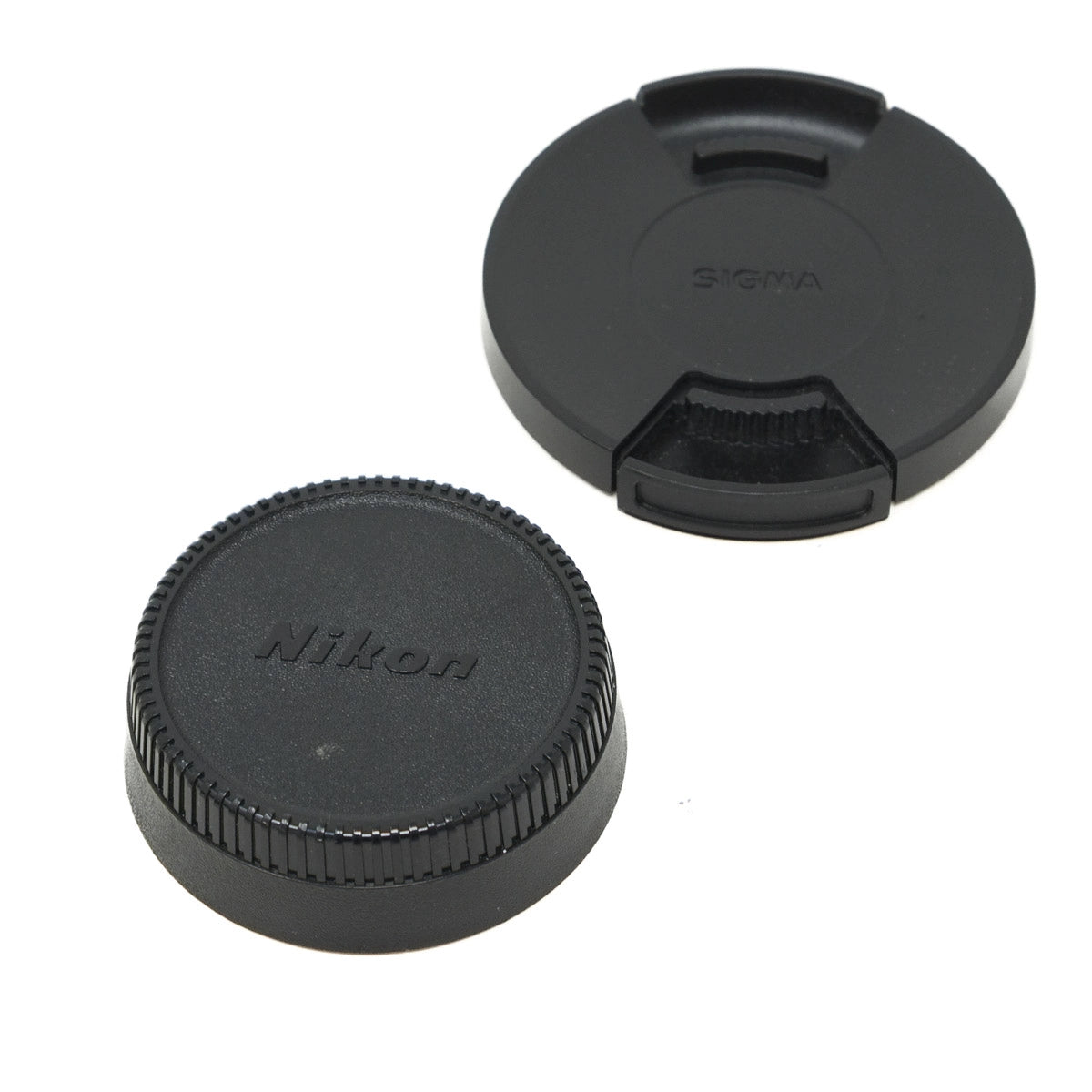 Two camera lens caps, one with Nikon logo and the other with Sigma logo, on a white background.