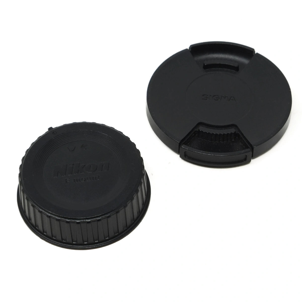 Two black camera lens caps with Nikon and Sigma branding on a white background