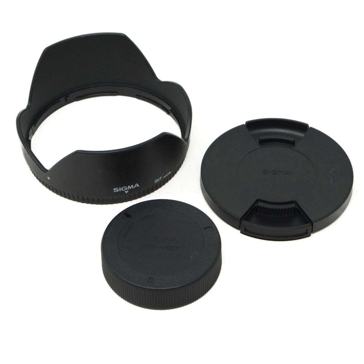 Sigma camera lens accessories including a lens hood, front and rear caps on a white background