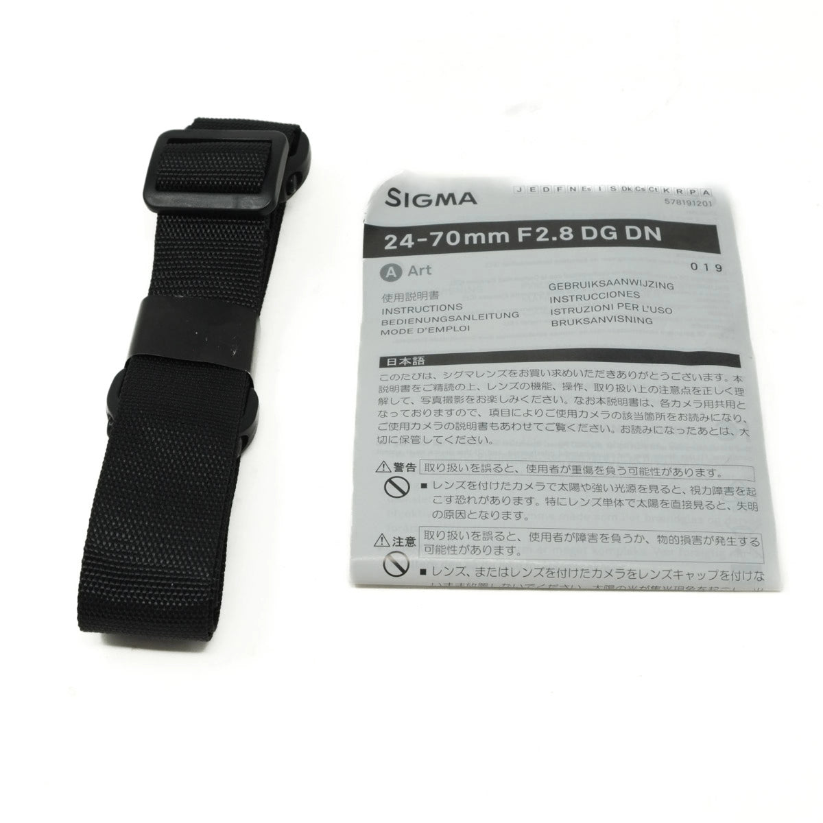 Sigma camera lens with strap and instruction manual on a white background
