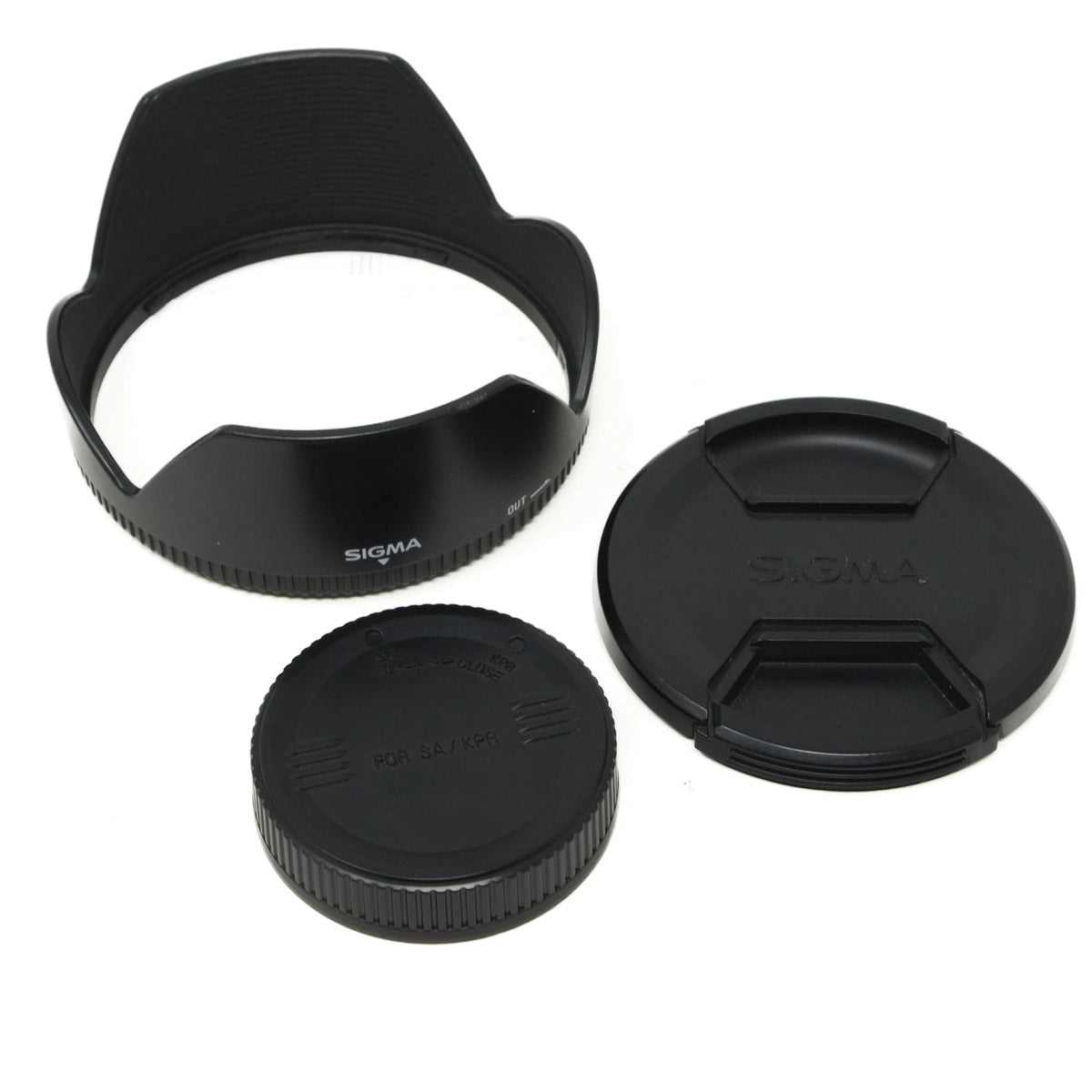 Sigma camera lens accessories including a lens hood, front and rear caps on a white background