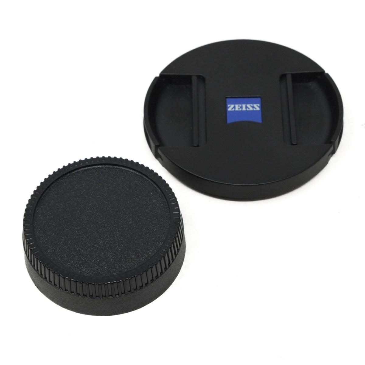 Two black camera lens caps with Zeiss logo on a white background