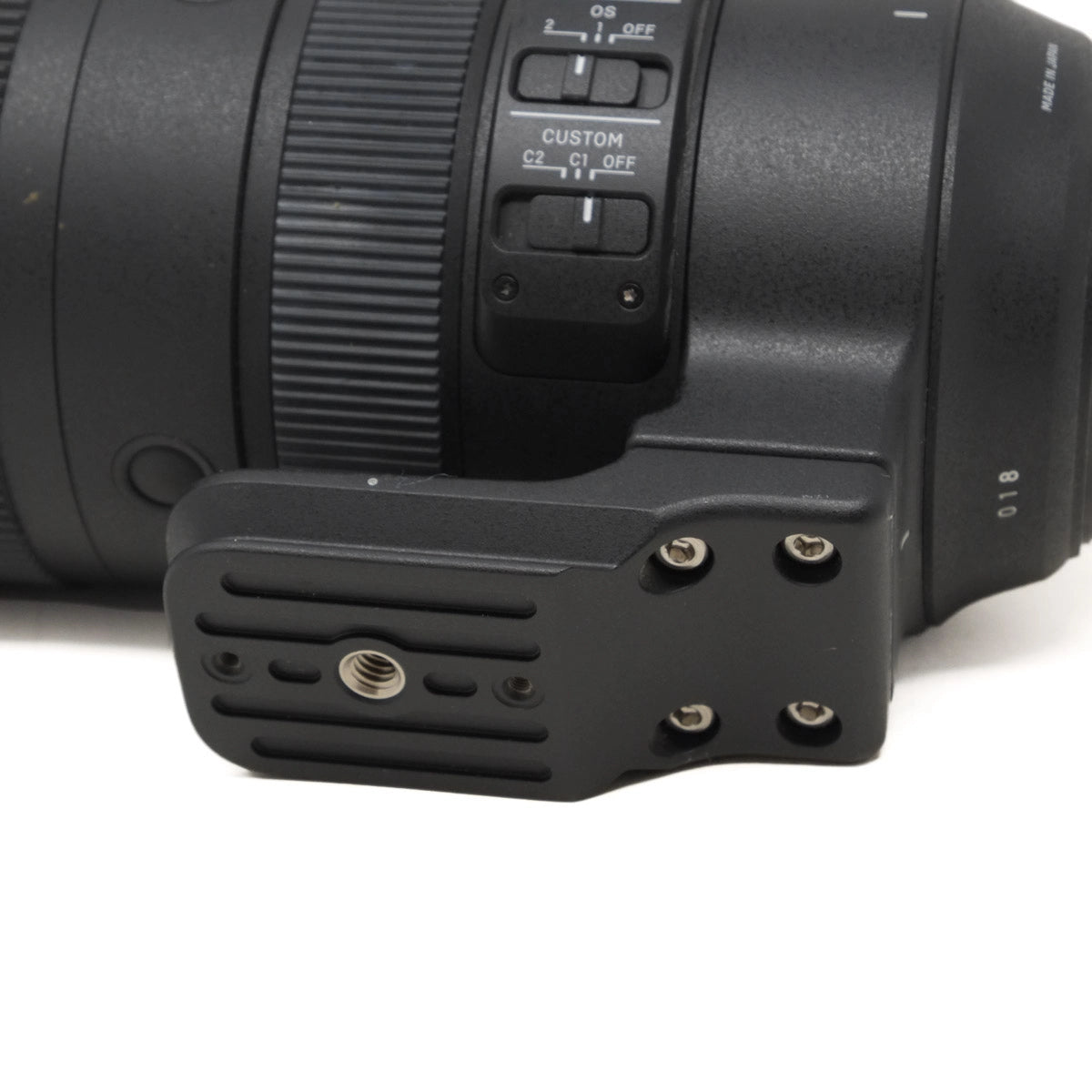 Close-up of a camera lens with control buttons on a white background