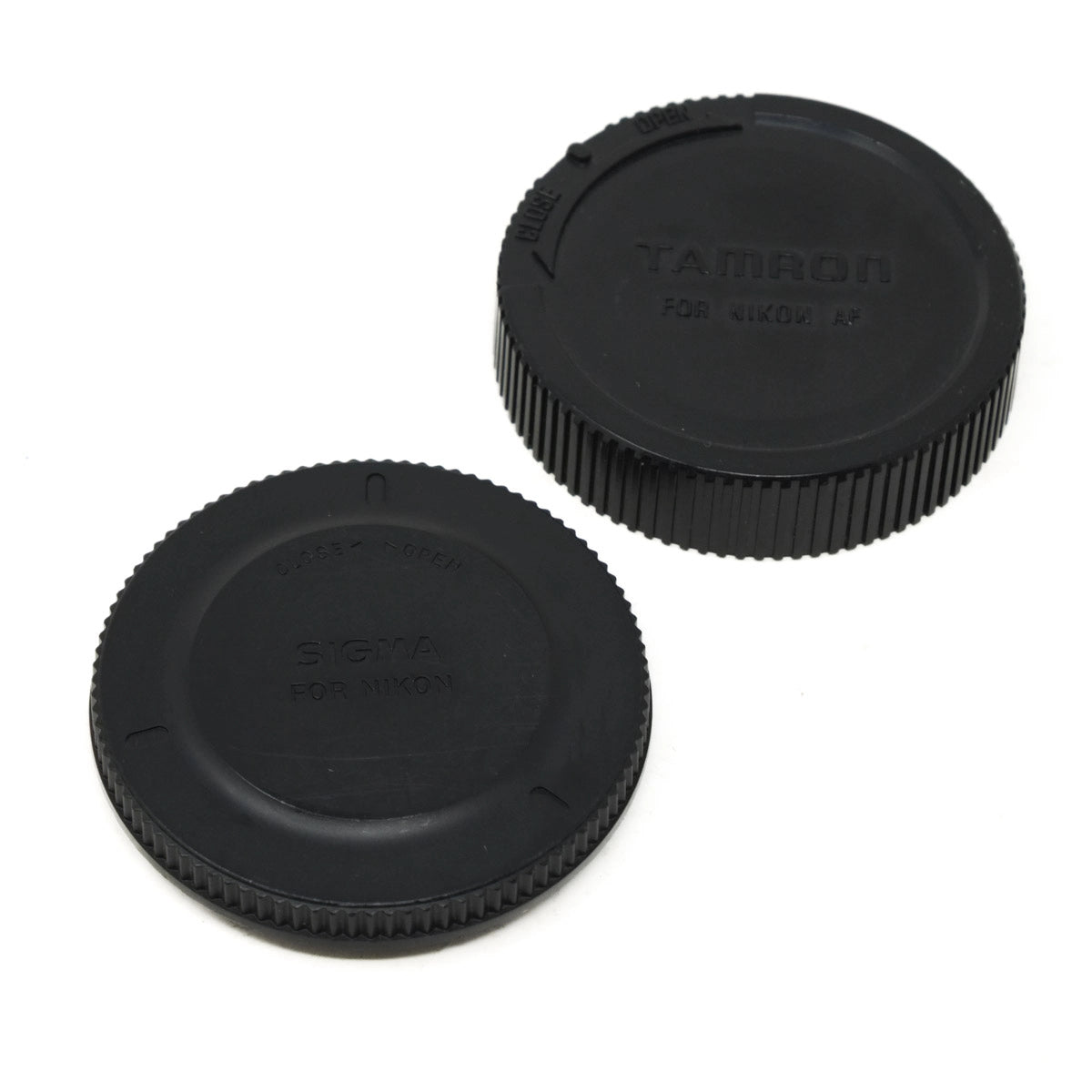 Two black camera lens caps with 'Tamron' and 'Sigma' branding on a white background.