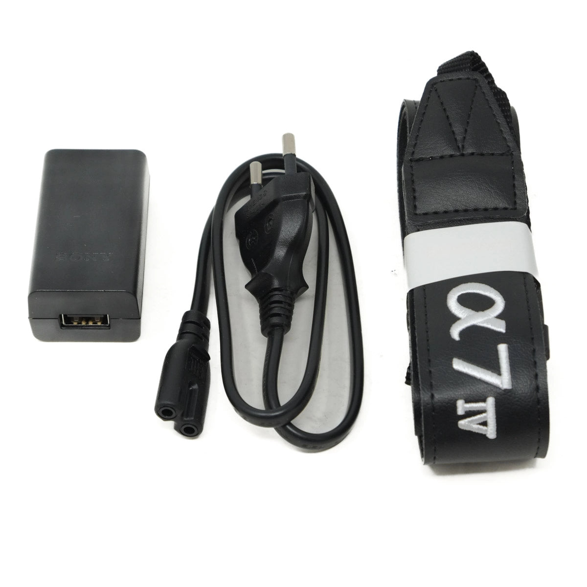 Camera strap with 'α7 III' branding, power adapter, and cable on a white background
