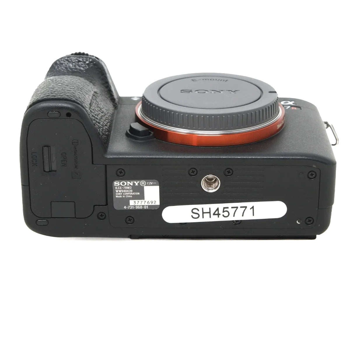 Sony A7R III mirrorless camera body in black, showing the rear side with the grip, lens mount, orange ring accent, and a white serial sticker labeled SH45771.