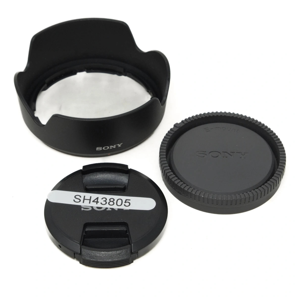 Sony camera lens cap, hood, and body cap on a white background