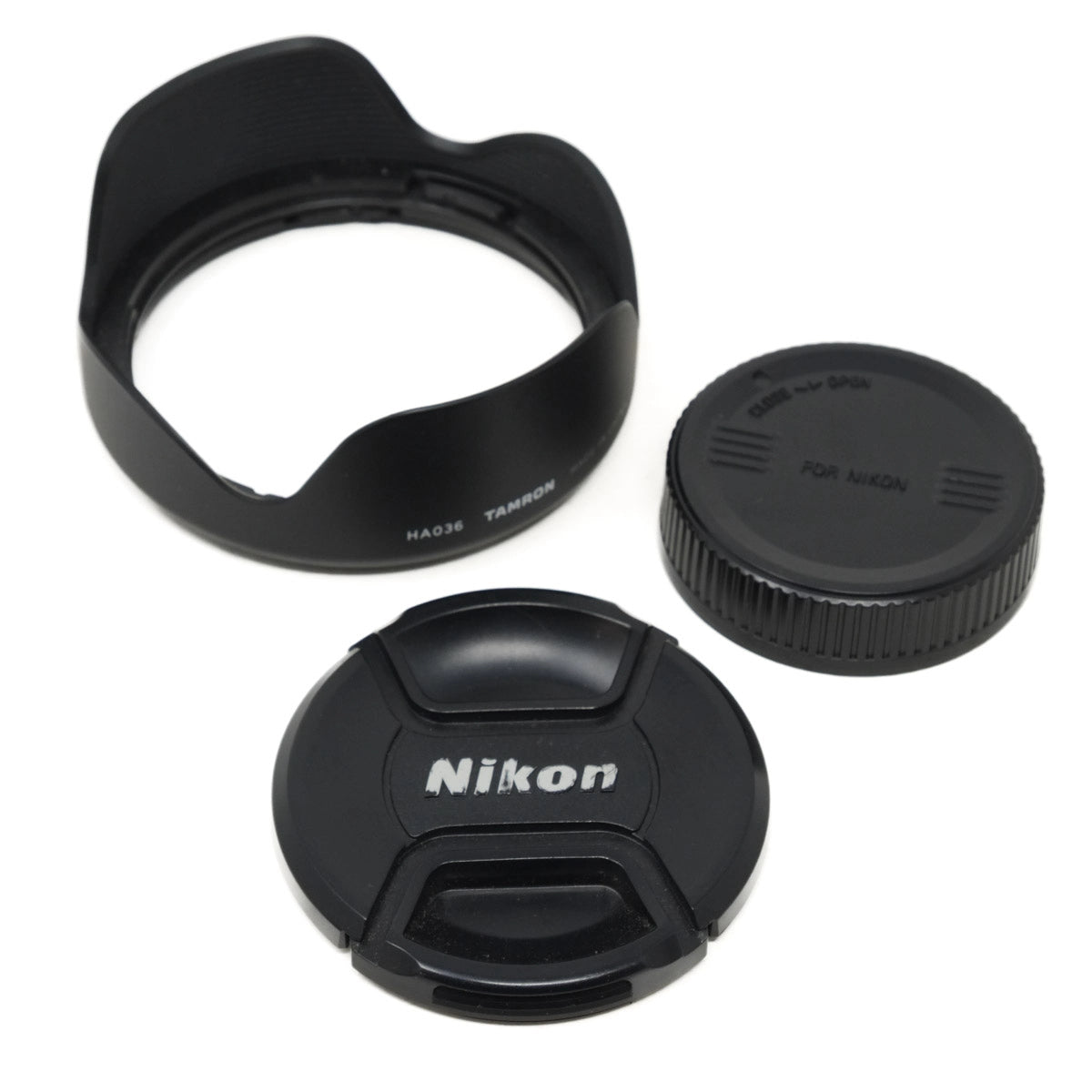 Nikon lens cap, lens hood, and front lens cover on a white background