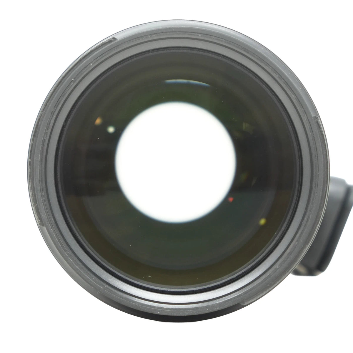 A close-up shot of a camera lens with a dark gray metal rim and a clear glass lens element showing a bright white center, isolated on a white background.