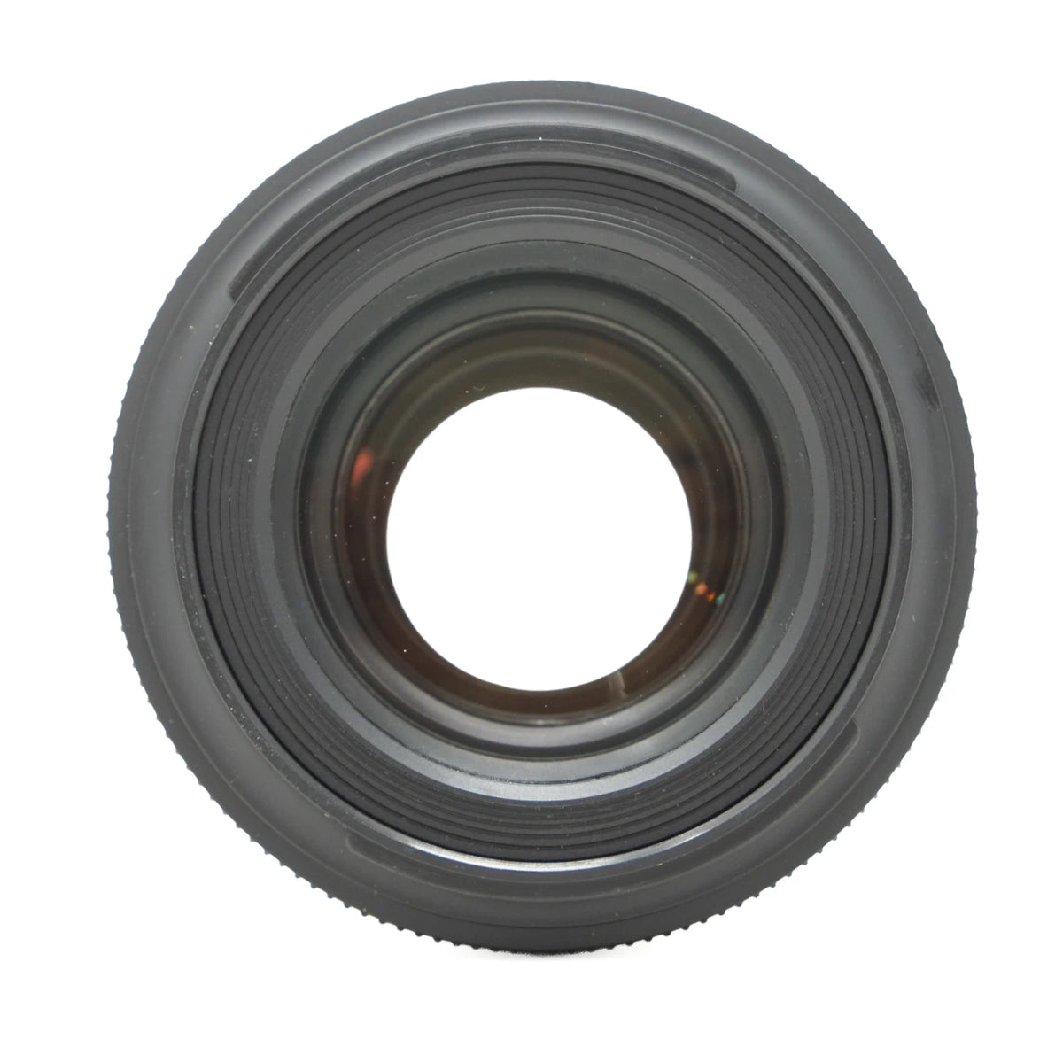 A close-up, top-down view of a black camera lens with concentric ring details and a textured outer edge, isolated on a white background.