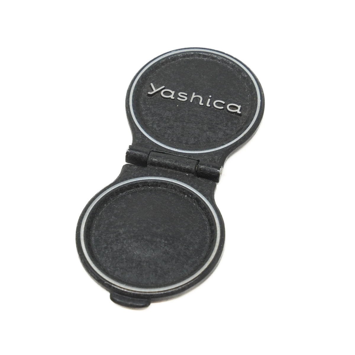 Black Yashica camera lens cap on a white background