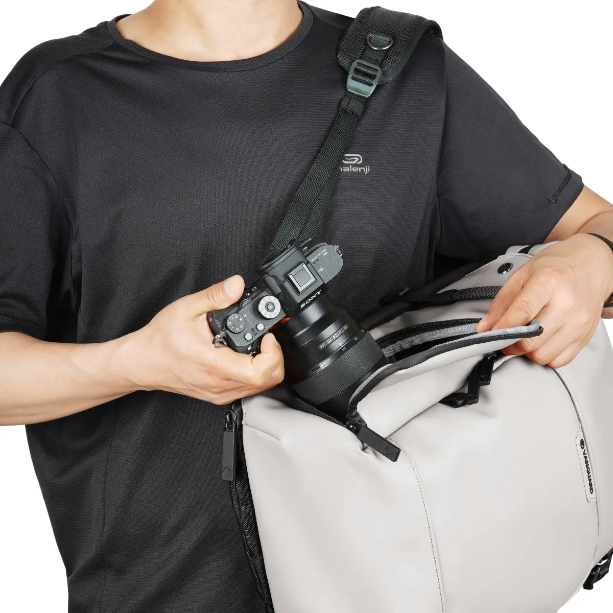 Person holding a camera and a backpack with a visible brand logo on a white background