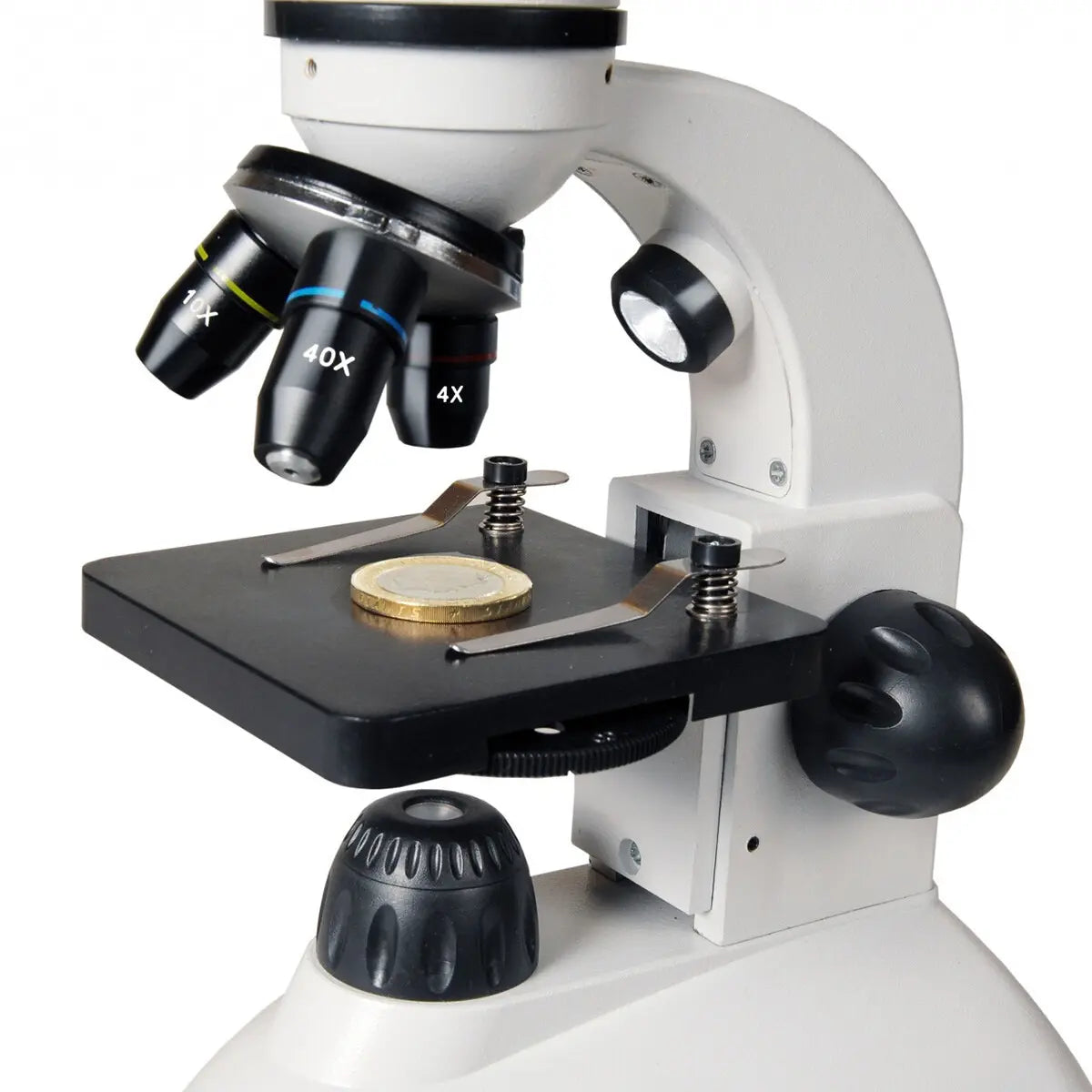 Microscope with objective lenses and stage on a white background