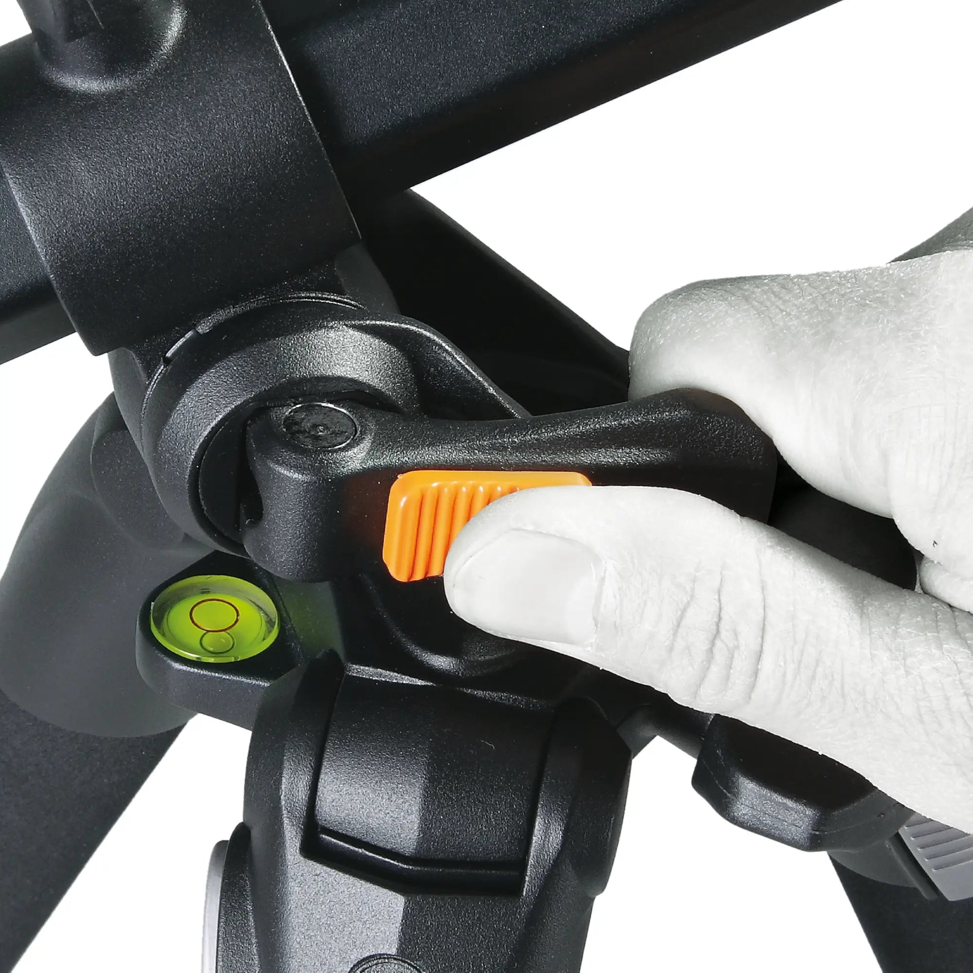 Close-up of a person adjusting a black tripod with an orange lever on a white background